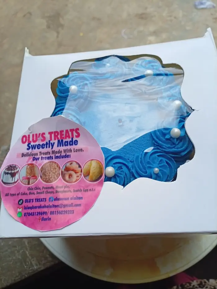Blue and white cake boxed with an Olu's Treats sticker