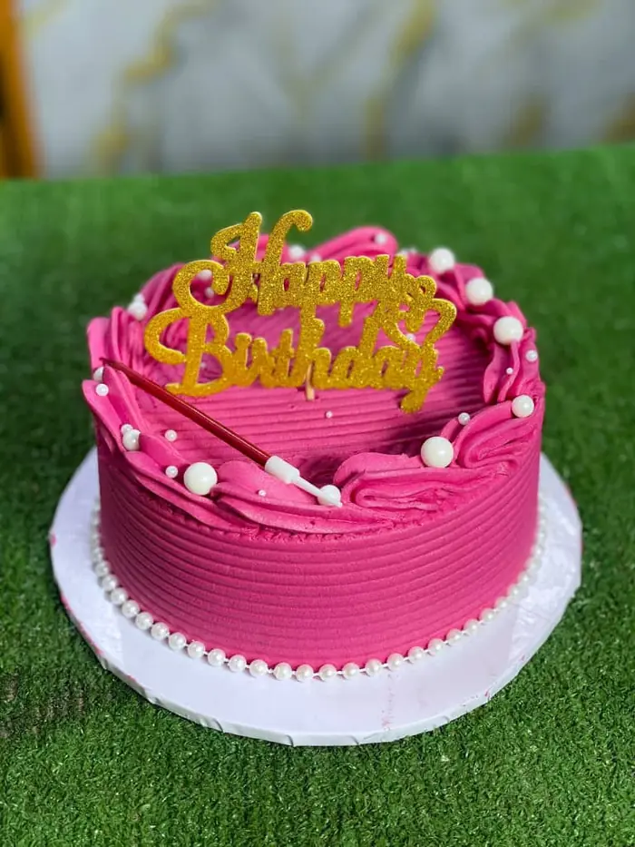 Pink birthday cake with gold topper